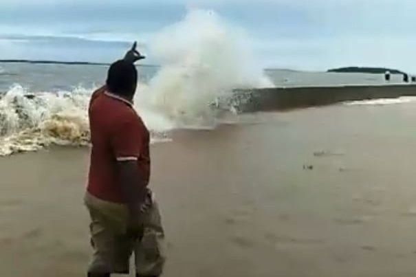 A wave crashes over the new seawall on Saibai Island.