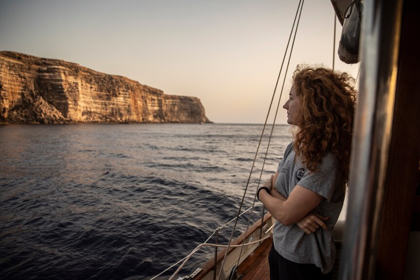 A woman looks out at Lampedusa Island.