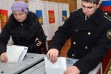 Russia votes- a navy officer and a woman cast their ballots in Vladivostok