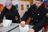 A Russian navy officer and a woman cast their ballots during the parliamentary election in Vladivostok on December 4, 2011.