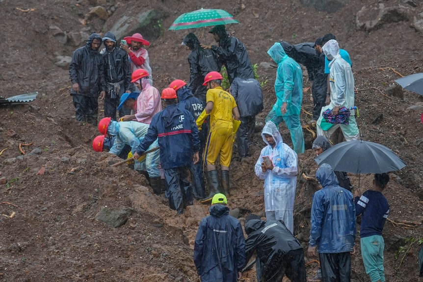 Rescuers try to take out the body of a victim at a site of a landslide in India.