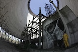 Street artist Guido van Helton with mural in Chernobyl Reactor 5