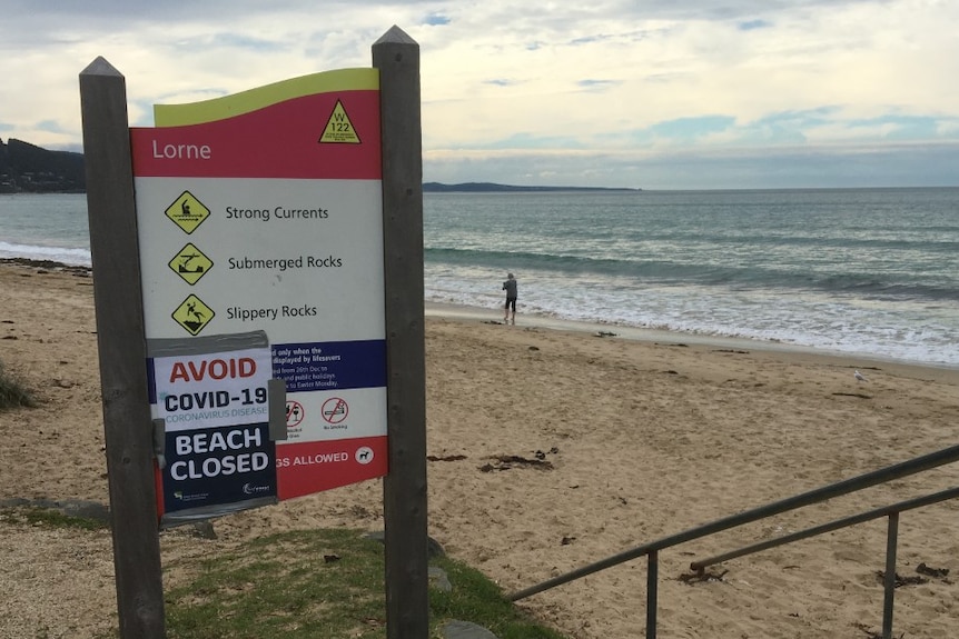 A sign on Lorne beach says the beach is closed due to COVID-19.