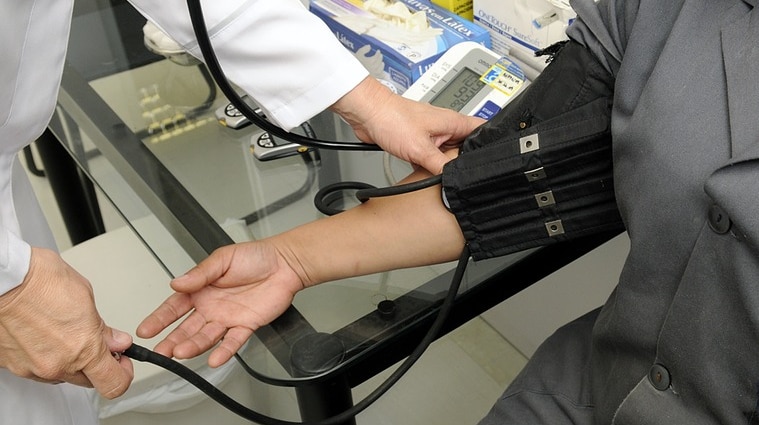 Doctor checks patient's blood pressure.