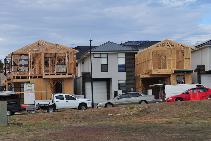 A group of four townhouses, two of which are under construction