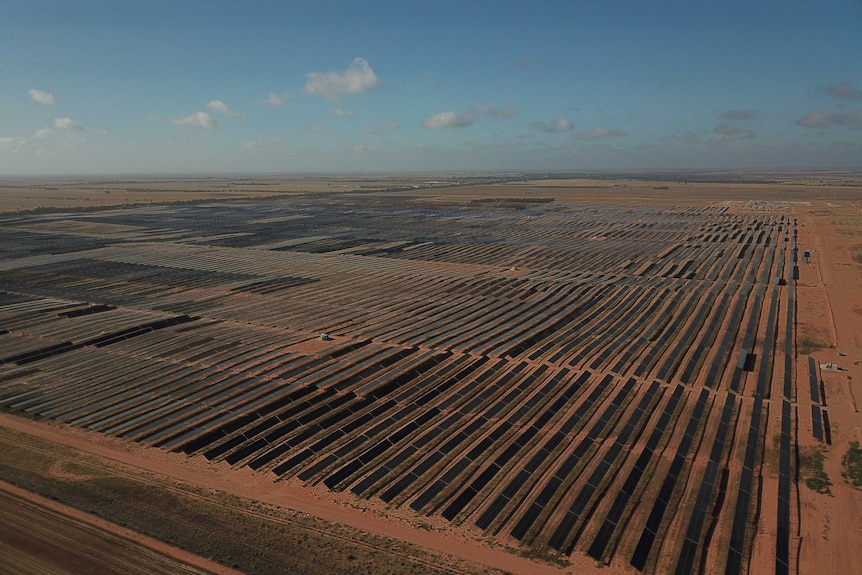 Aerial of a huge solar farm on a fairly denuded landscape.