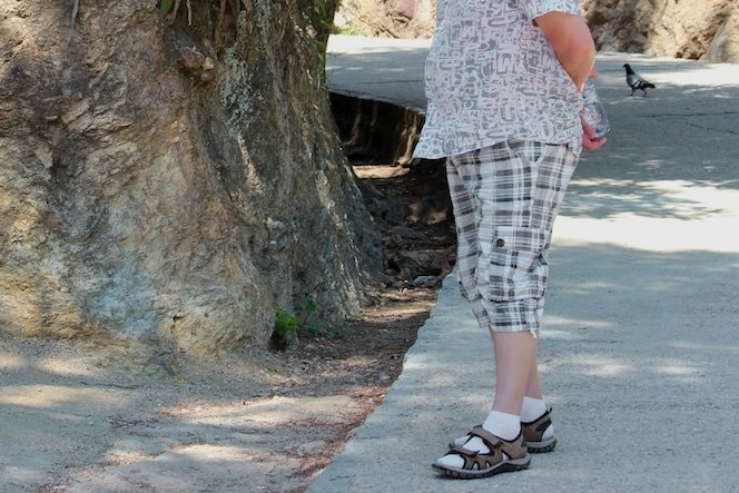 man wearing shorts, socks and sandals 