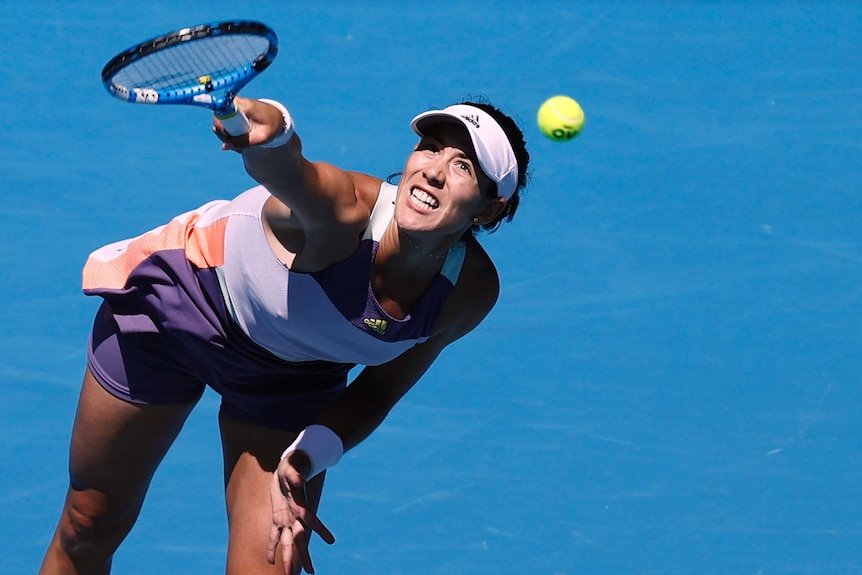 A female tennis player serves to an opponent at the Australian Open.