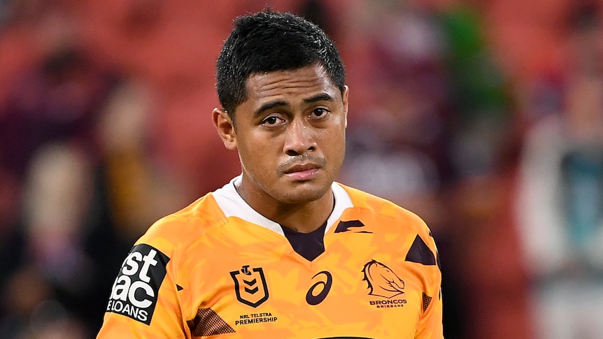 A Brisbane Broncos NRL player stands on his own on the field after a match in 2021.