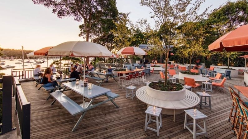 An outdoor deck at The Newport, with tables overlooking Pittwater water.