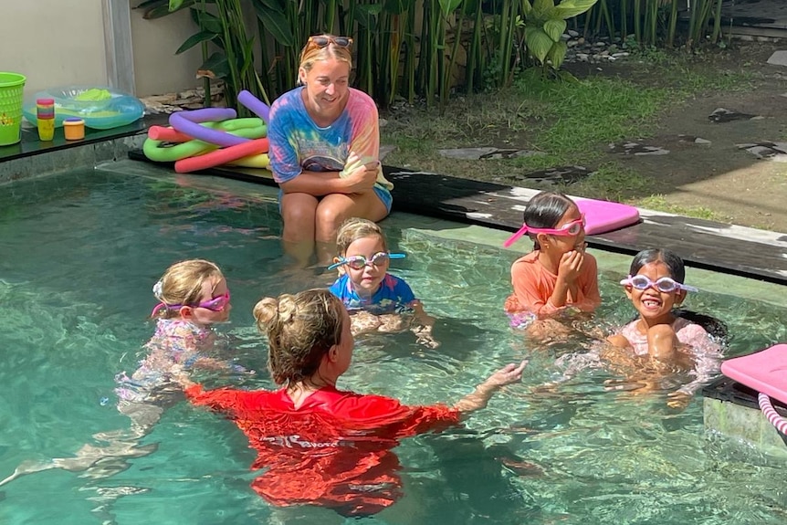 Two Australians teaching Indonesia children how to swim.