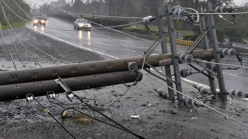 Cars drive past collapsed power lines, as super typhoon Meranti skirts Pingtung county in southern Taiwan. 