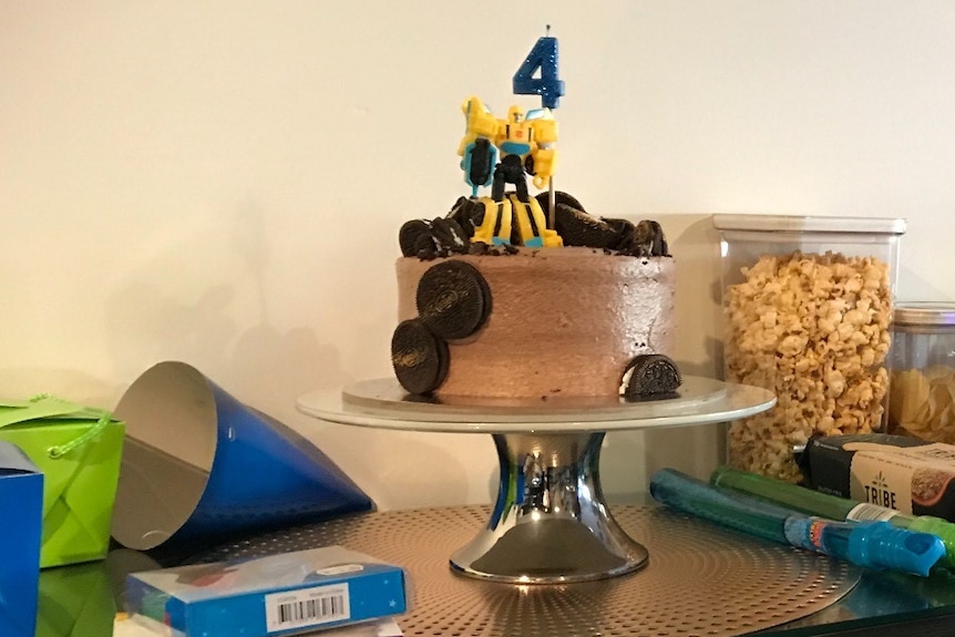 A birthday cake with a transformer toy on top for a story on kids birthday parties
