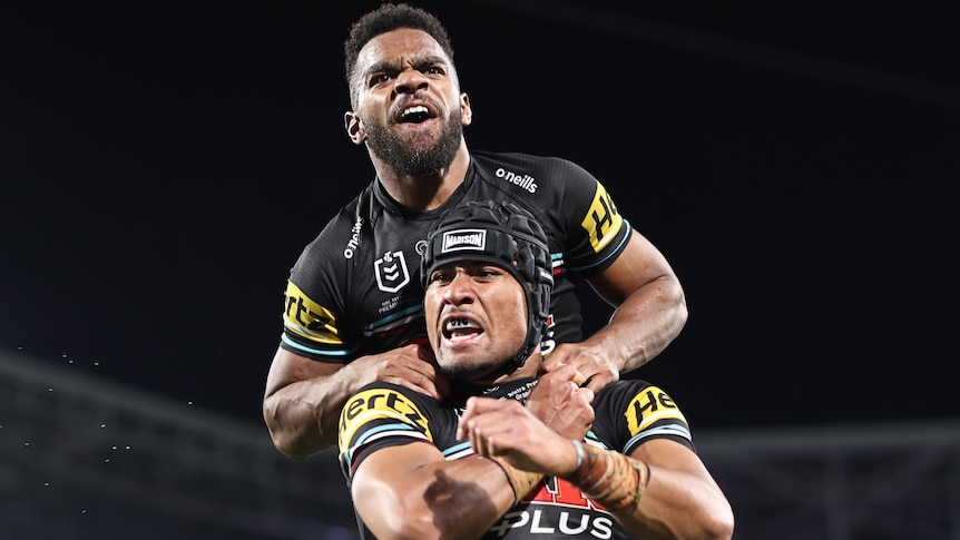 Two Penrith Panthers players celebrate a try in the NRL grand final.