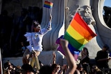 A drag queen holds up a gay pride flag in a crowd of protesters outside parliament in Budapest. 