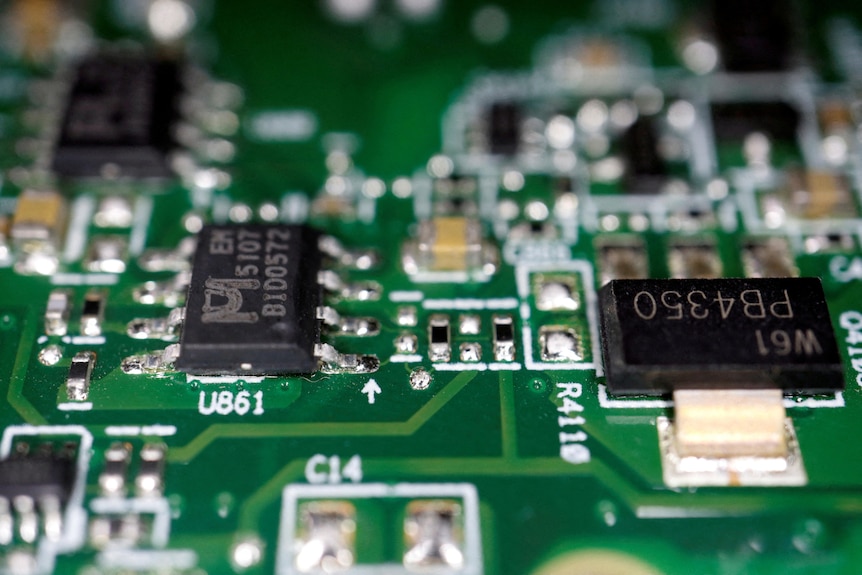 closeup of green circuit board components of a semi conductor chip.