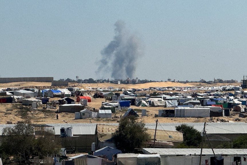 Smoke rises from the tent camp 