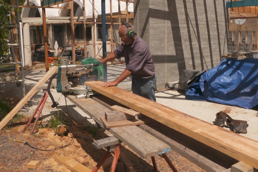 Photo of a man cutting timber.