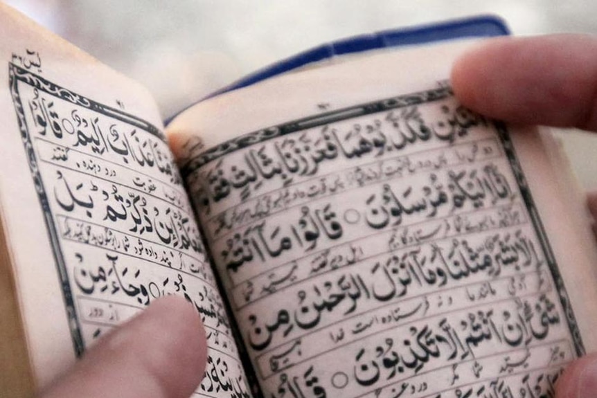 A Muslim pilgrim reads the Koran.