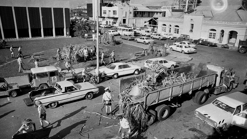 Police and volunteers load piles of wreckage on to the back of a truck in Darwin after Cyclone Tracy
