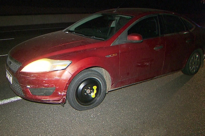 A red car with a spare wheel on