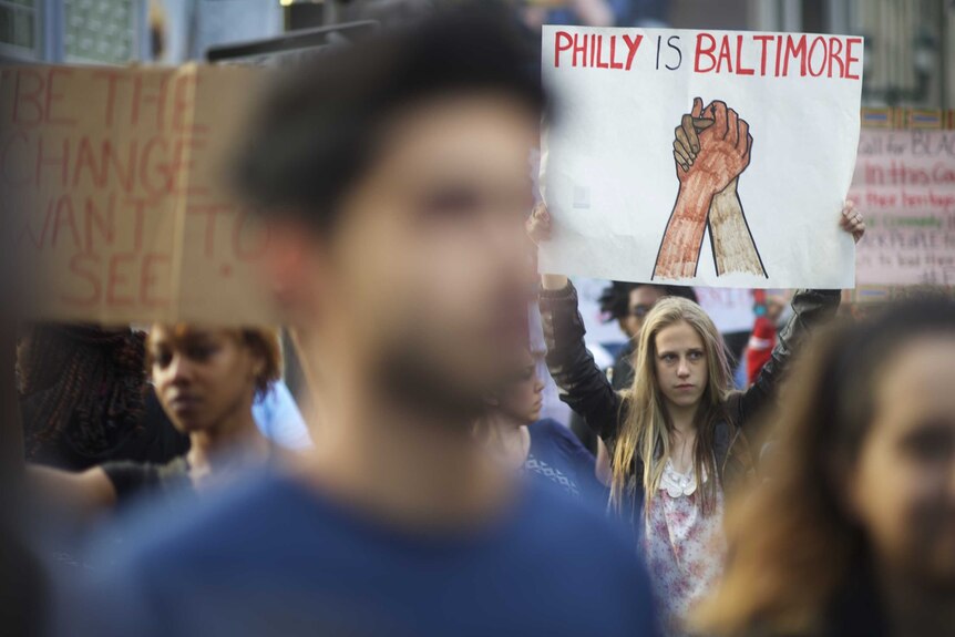 A protestor in Philadelphia holds a sign supporting Baltimore