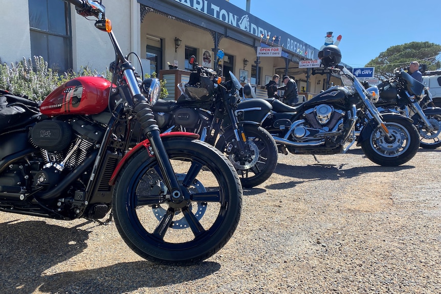 A line of parked motorcycles outside a pub.