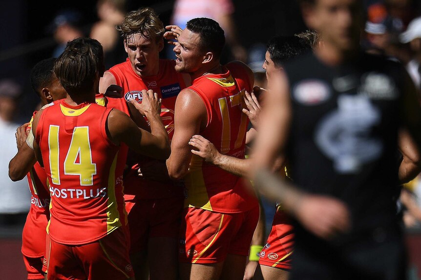 Tom Lynch of the Suns (2nd L) reacts after kicking a goal against Carlton at Docklands.