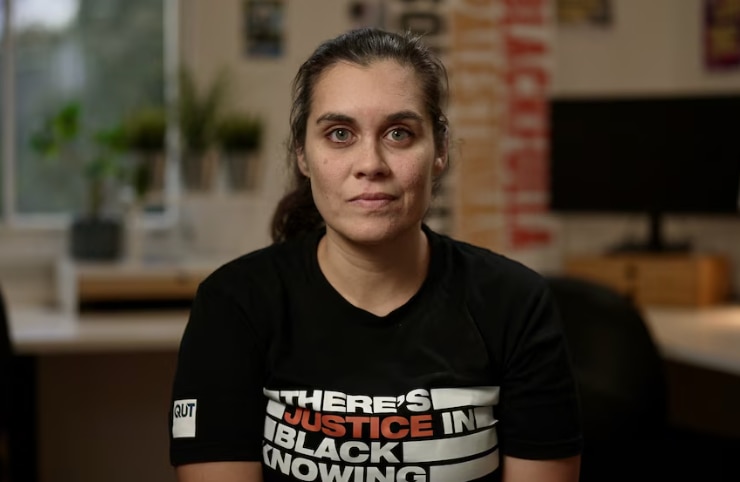 A young woman looks seriously into the camera.
