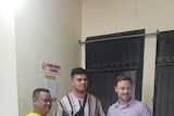 David Fifita, centre, poses for a photo with a man on his left and another on his right outside what appears to be a cell.