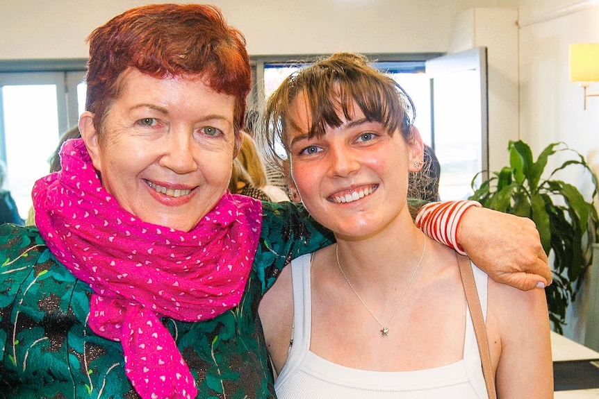 Middle aged woman with short hair and young woman with longer hair smile at the camer