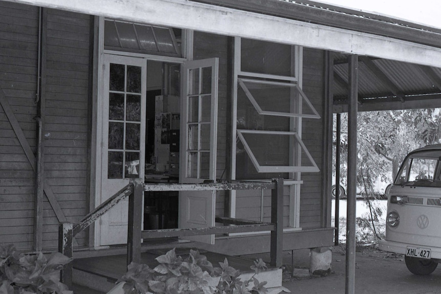 A black and white close-up picture of a classroom building at Broome Primary School, with a Kombi van near the front door.