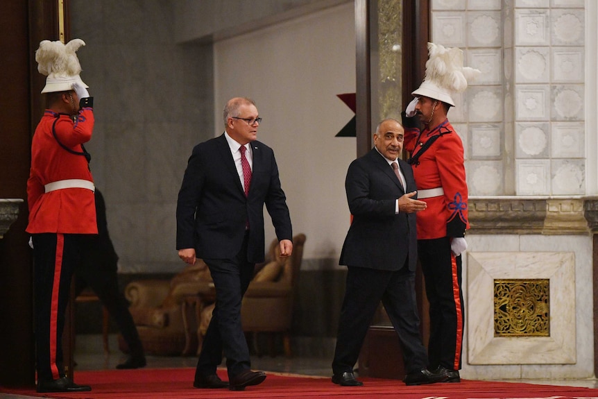 Mr Morrison and Mr Abdul-Mahdi walk into the Prime Minister's Palace. Two guards salute them.