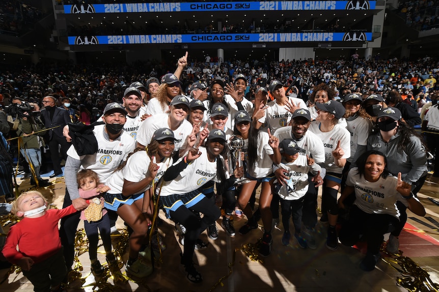 WNBA champions smiling for a photo with the trophy