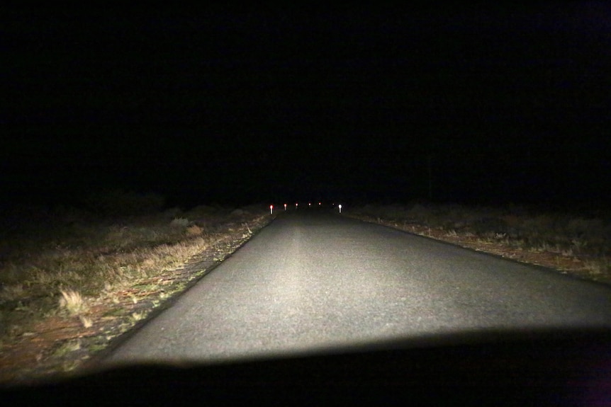 A road stretching into the distance pictured at night time