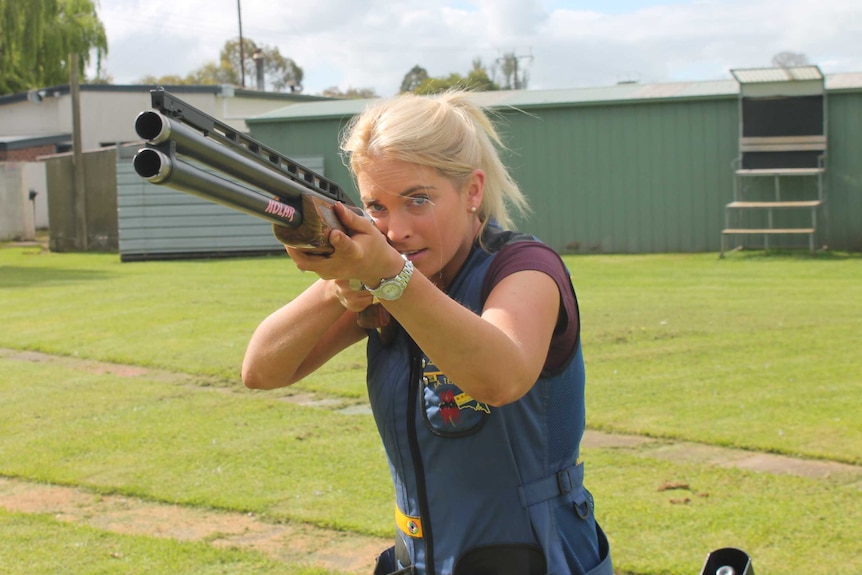 Liz Rymill, SA representative sport shooter stands with rifle at a gun range.