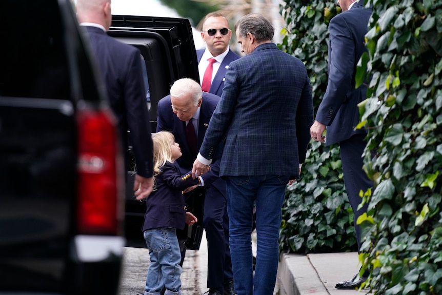 President Joe Biden talks to his grandson Beau as son Hunter Biden looks on