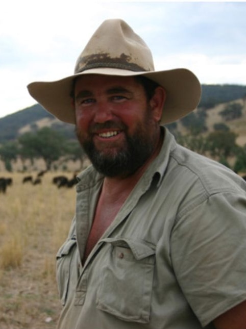 Man in cattle paddock with hat on