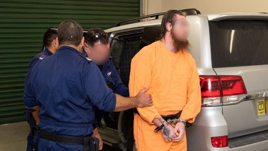 Police officers arrest a man wearing an orange jumpsuit