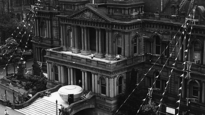 A black and white photo of a cartoonish-looking space ship on the steps of Sydney's Town Hall.