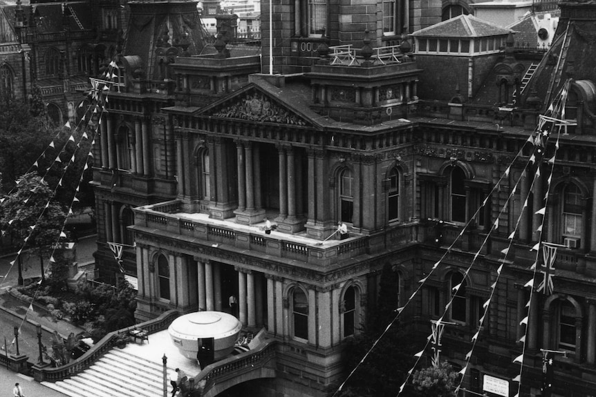 A black and white photo of a cartoonish-looking space ship on the steps of Sydney's Town Hall.