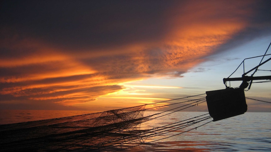 Sun sets over trawler boom in the Gulf of Carpentaria