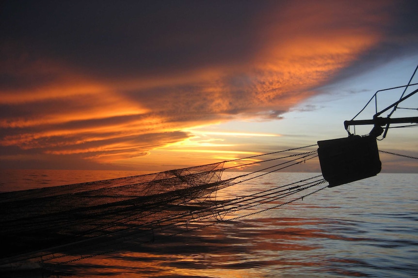 Sun sets over trawler boom in the Gulf of Carpentaria