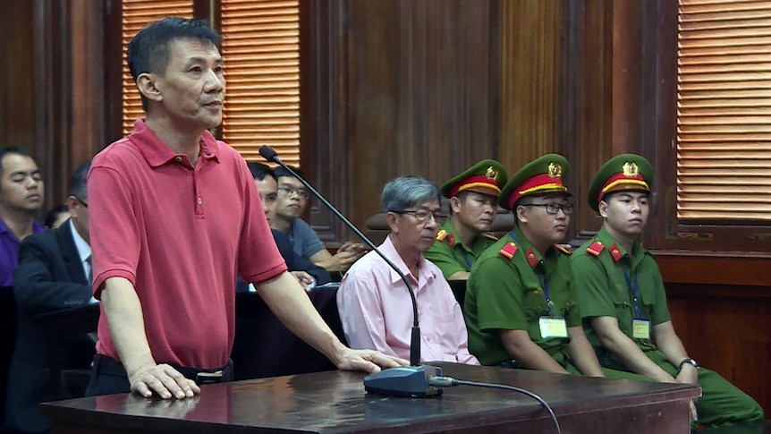 Michael Nguyen is standing on trial, in front of a microphone.