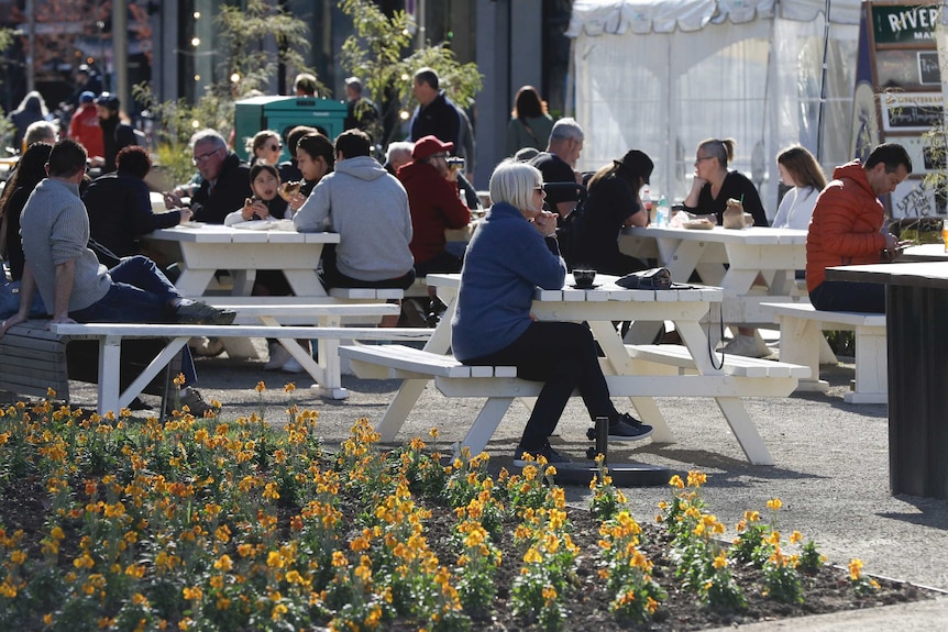 Customers enjoy lunch in the sunshine at the Riverside Market in Christchurch, New Zealand.