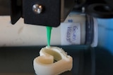 A 3D printer makes a heart shape from gouda cheese.