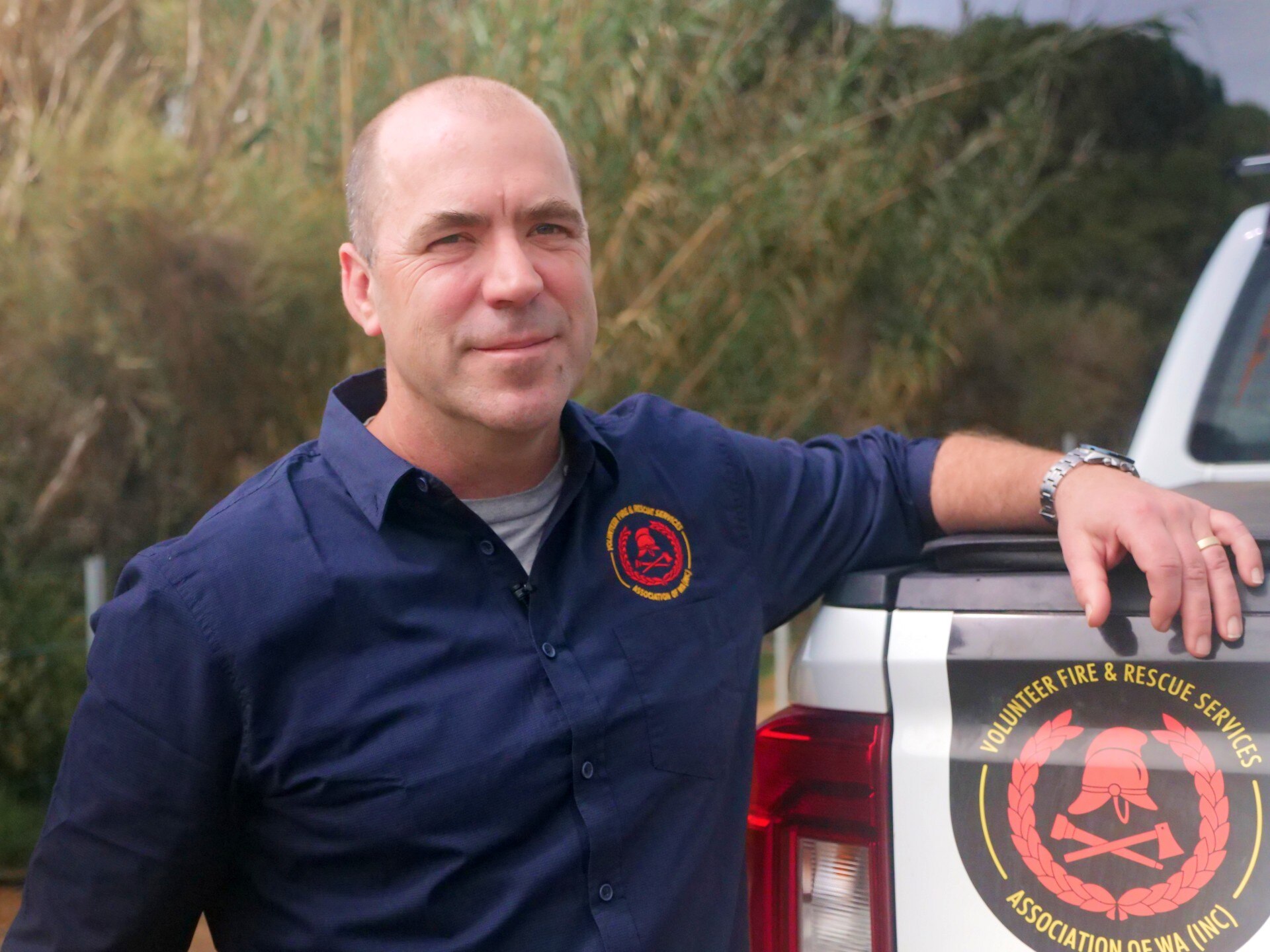 Un hombre se apoya en un camión.