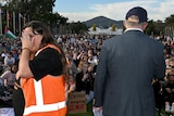 Sarah Wilson turns away in tears as Anthony Albanese addresses a rally outside parliament house
