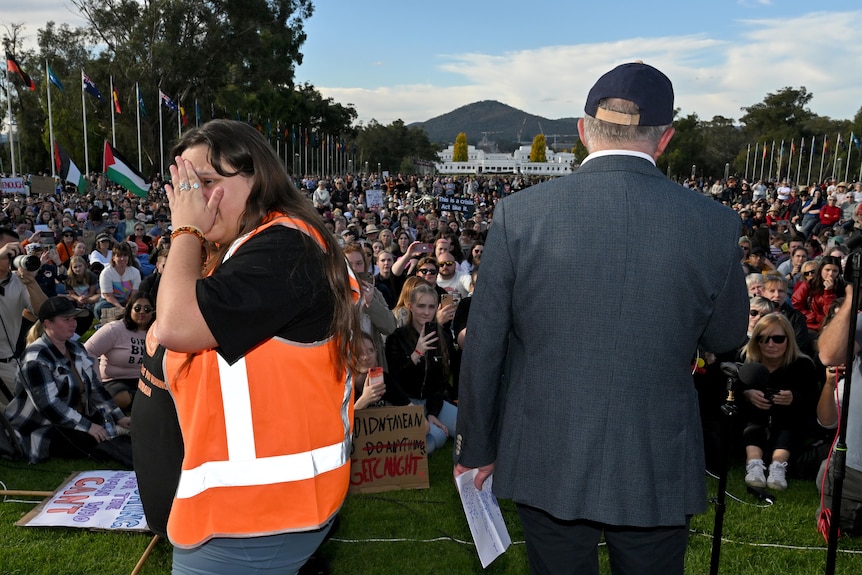 Sarah Wilson turns away in tears as Anthony Albanese addresses a rally outside parliament house