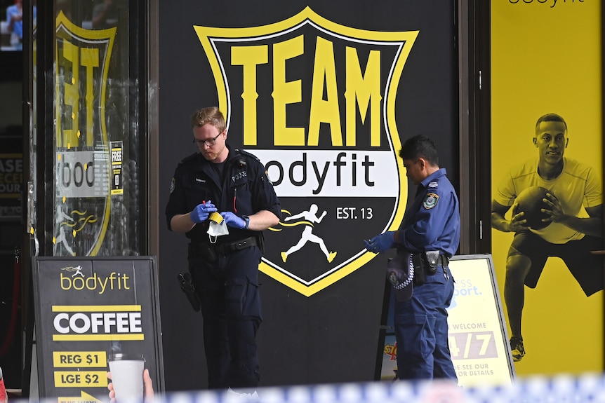 Gloved officers walk outside a business residence 